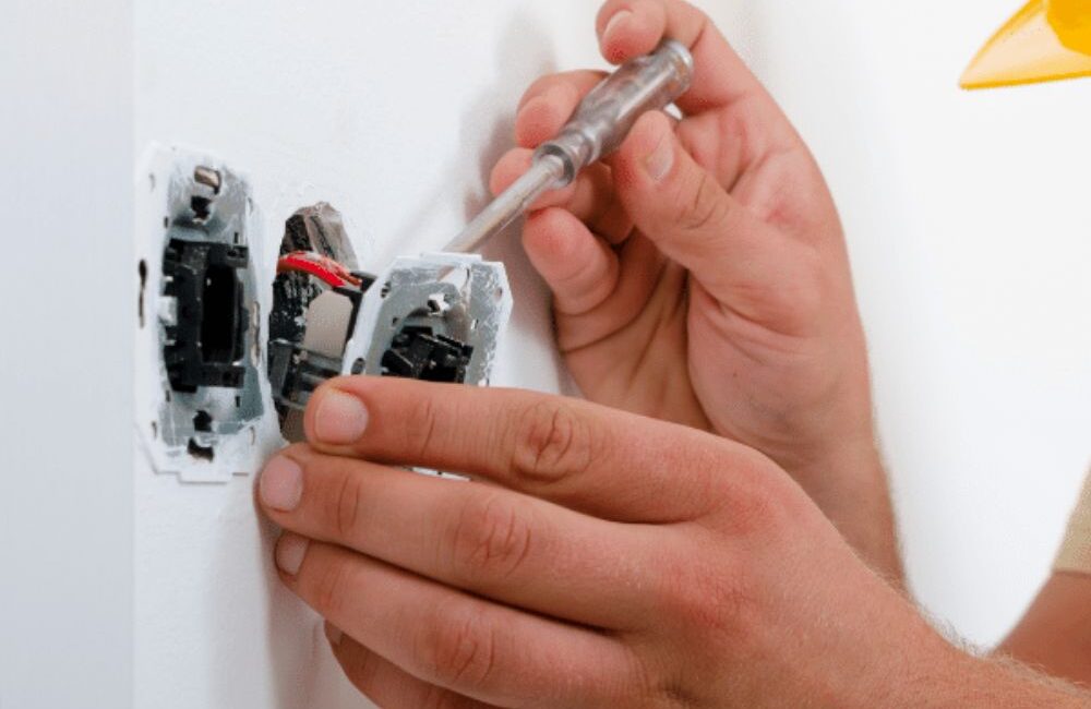 Elektricien sluit een dubbel stopcontact aan